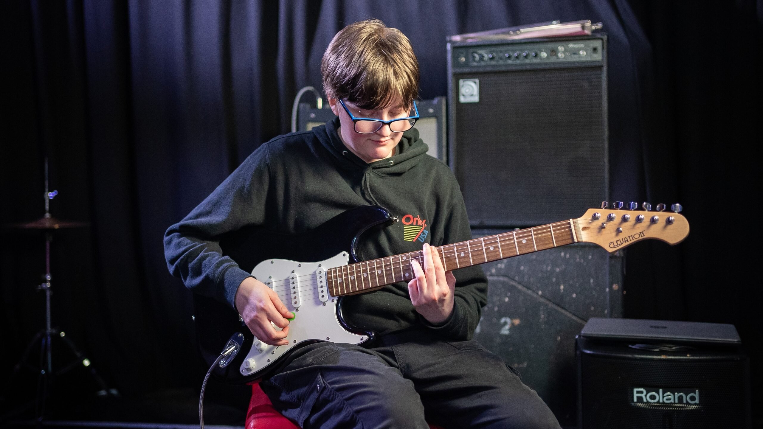 Young person playing a guitar