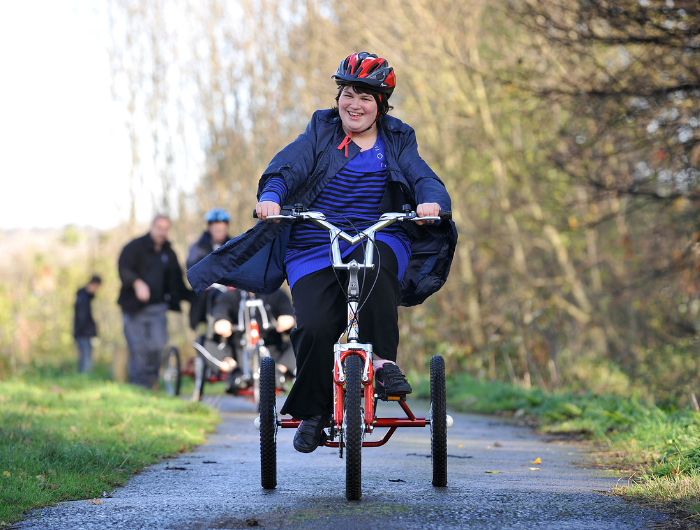 Young girl Kirsty on an electric trike cycling along a path