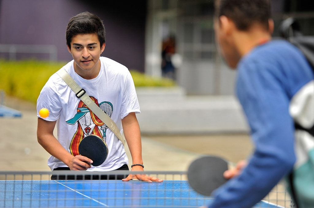 Two young men playing ping pong