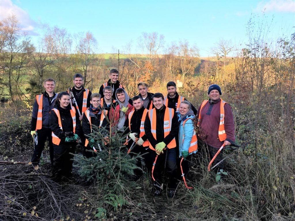 Young employees of Schneider Electric volunteering wearing high vis jackets