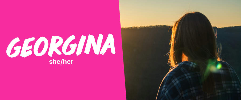 A split-design image with a bright pink left section containing the name 'GEORGINA' in bold, white, handwritten-style text, followed by the pronouns 'she/her' in a smaller, white sans-serif font. The right section shows the back of a person with long brown hair, wearing a dark plaid shirt, looking towards a sunset over a hilly landscape.