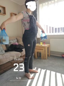 Participant exercising using bags of sugar as weights in living room