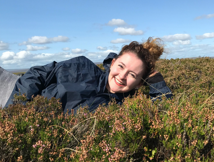 Girl with brown hair lying in field