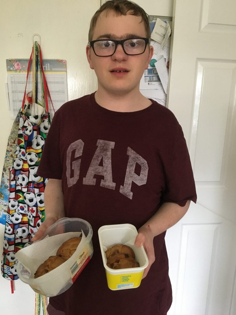 Young man wearing t-shirt holding baked goods