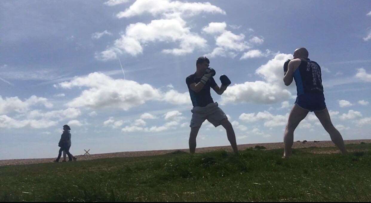Two boxers practising in a field