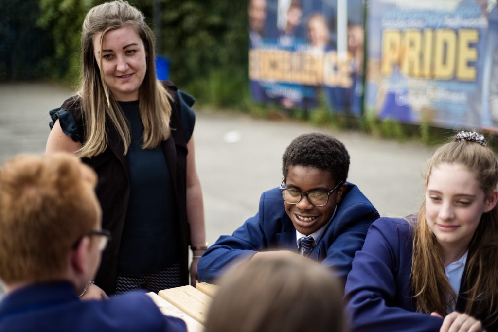 Group of students in school uniform talking with Leader