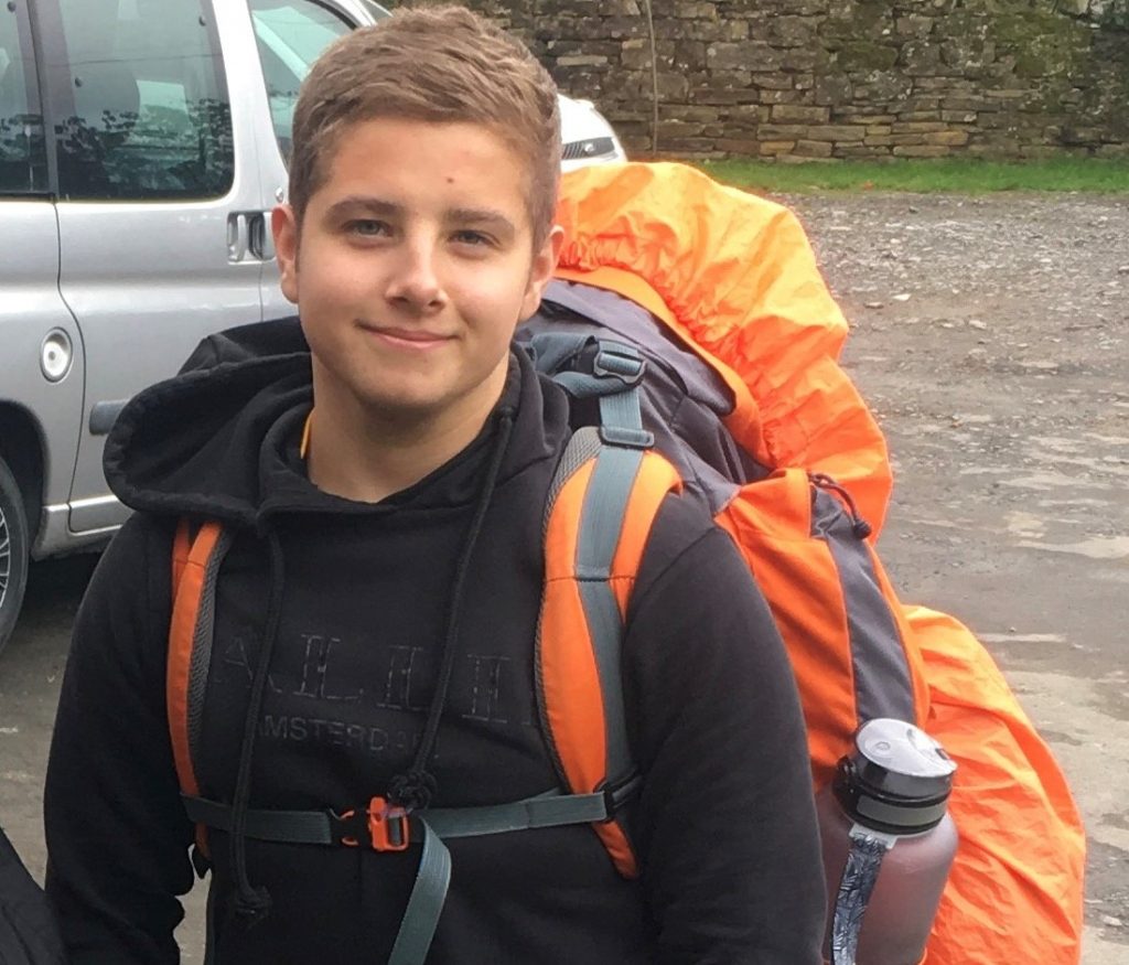 Joseph on expedition wearing orange backpack