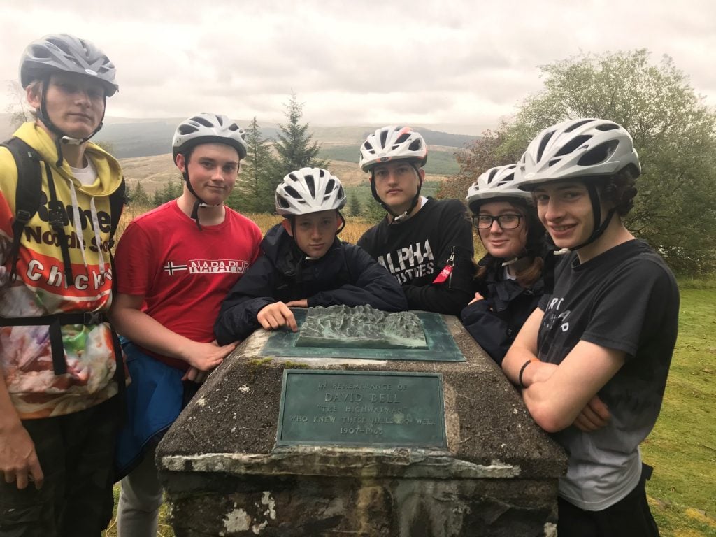 Group of young people on expedition wearing bike helmets