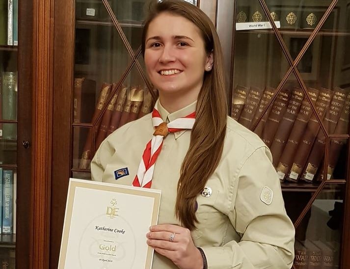 Katherine in Scout uniform holding Gold DofE certificate