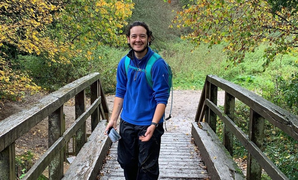 Luke standing on wooden bridge wearing blue jumper