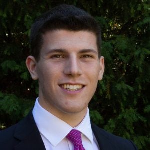 Young man in suit with pink tie and shirt smiling