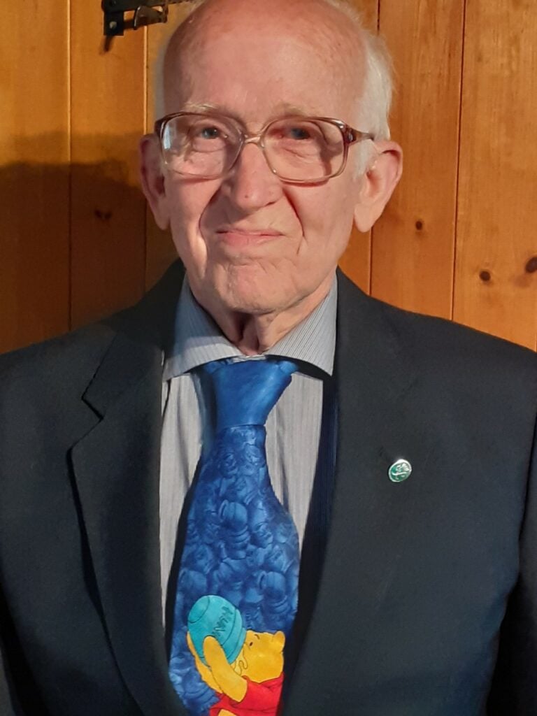 Paul wearing a suit with his D of E Silver badge on the lapel and a Winnie the Pooh tie.