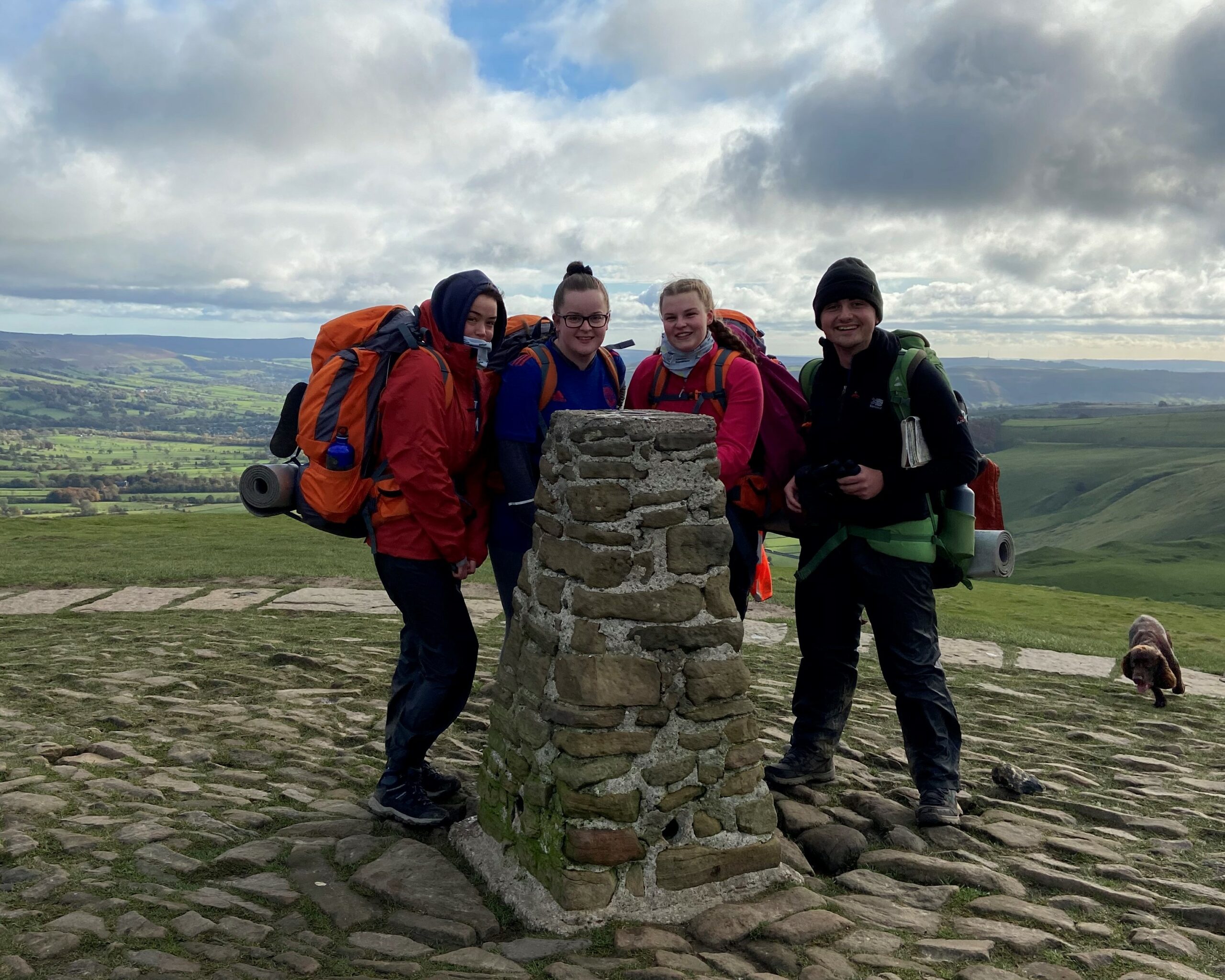 Four young people on expedition wearing outdoor kit