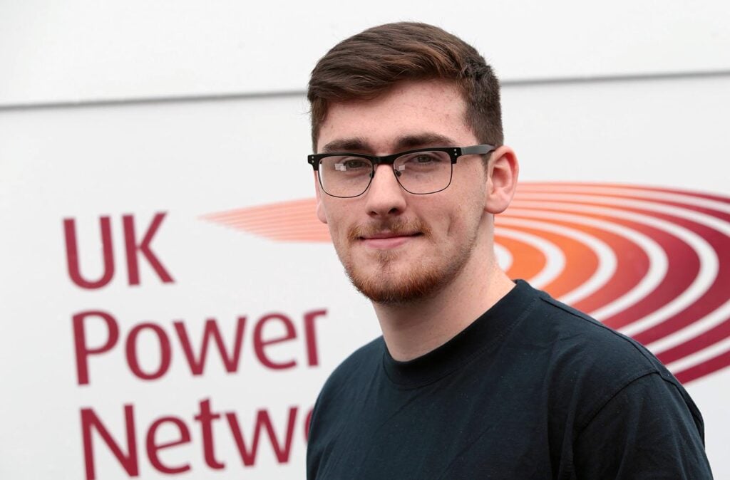 Josh Pavey headshot, wearing black top and glasses