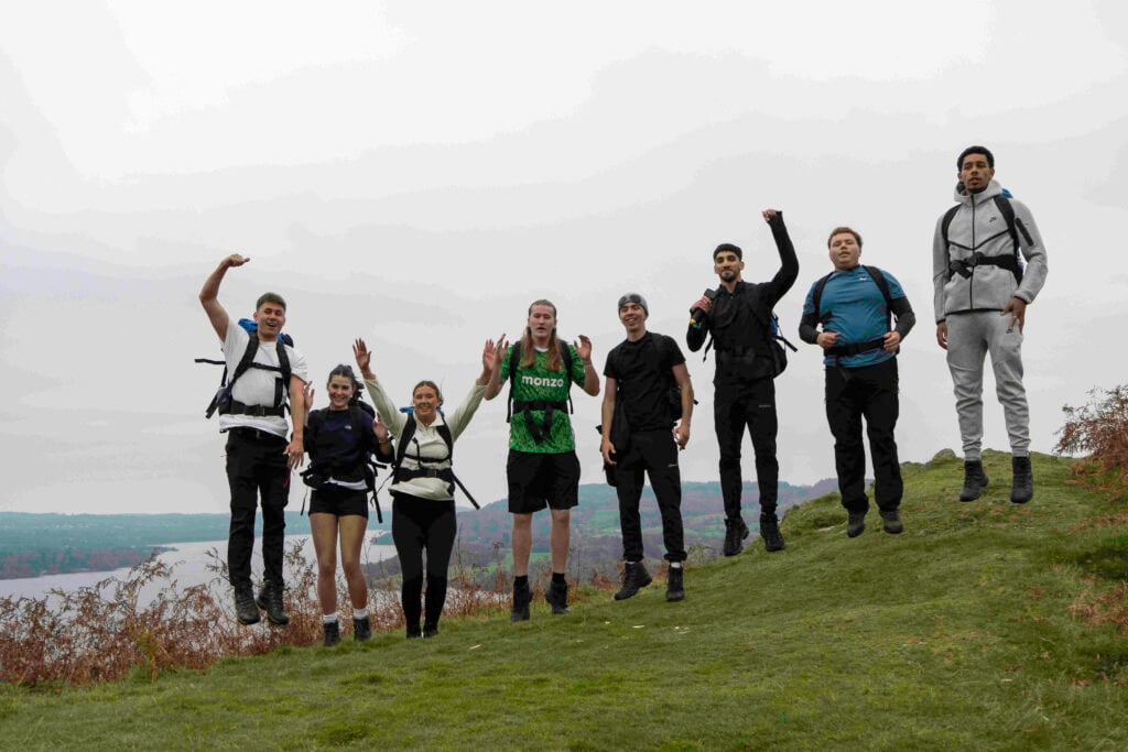 Eight young people standing in a row on a hilltop during their practice expedition.