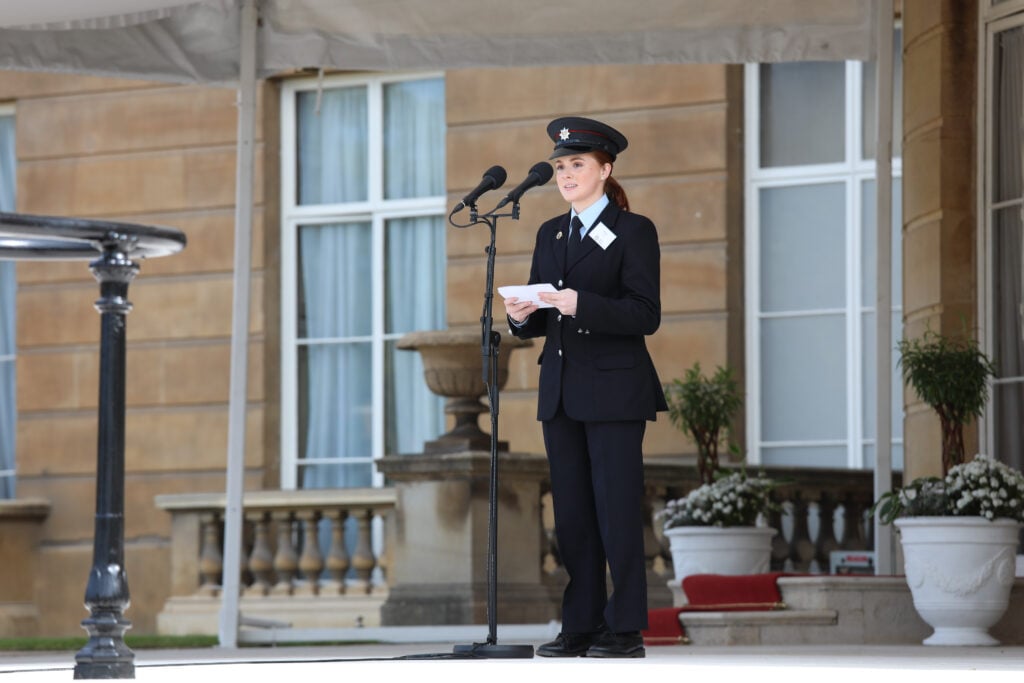 Ffion wearing a black uniform delivering a speech from the West Terrace at Buckingham Palace.