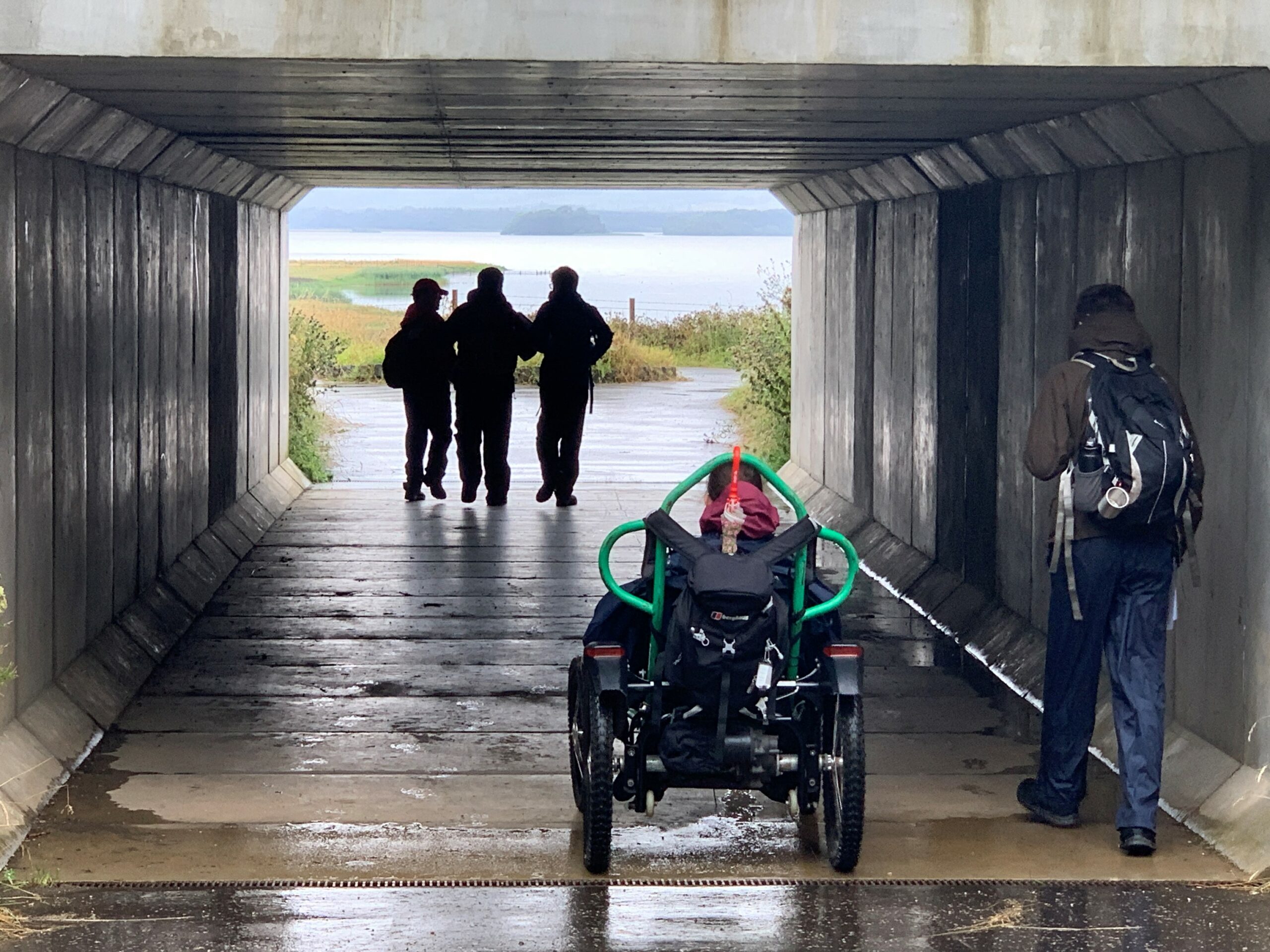 Photo of a group on an adapted expedition going through a tunnel with their backs to the camera