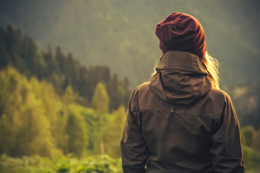 A young person looking out over a forest landscape.
