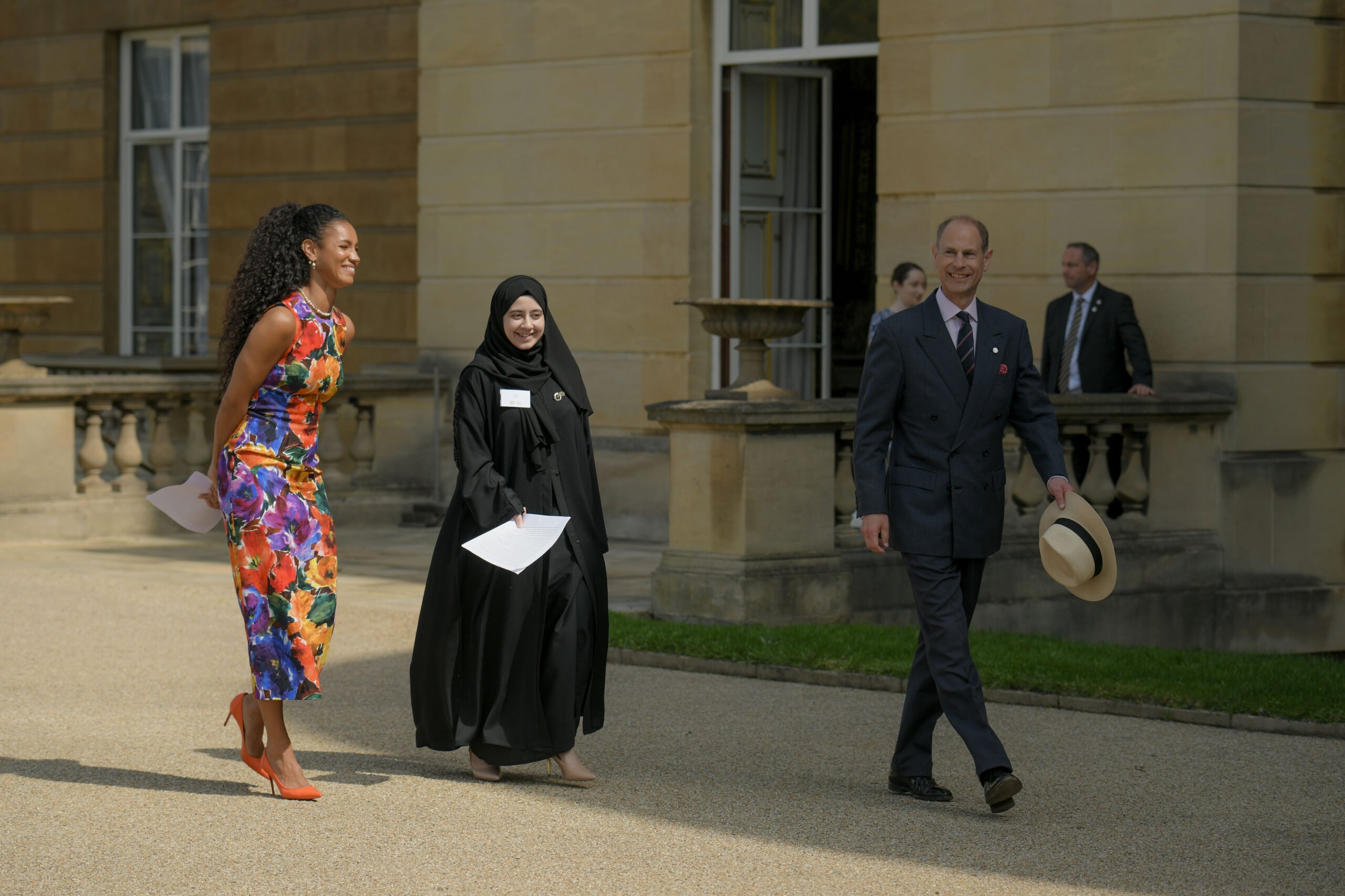 From left to right: Vick Hope, Ifrah Shafiq and HRH The Duke of Edinburgh walking on the West Terrace of Buckingham Palace.