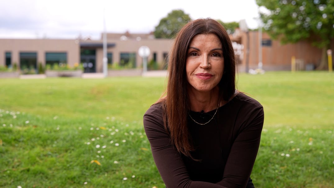 Headteacher Shivaun standing in front of a school and big grassy field.