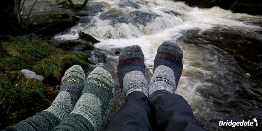 Two pairs of feet wearing Bridgedale socks