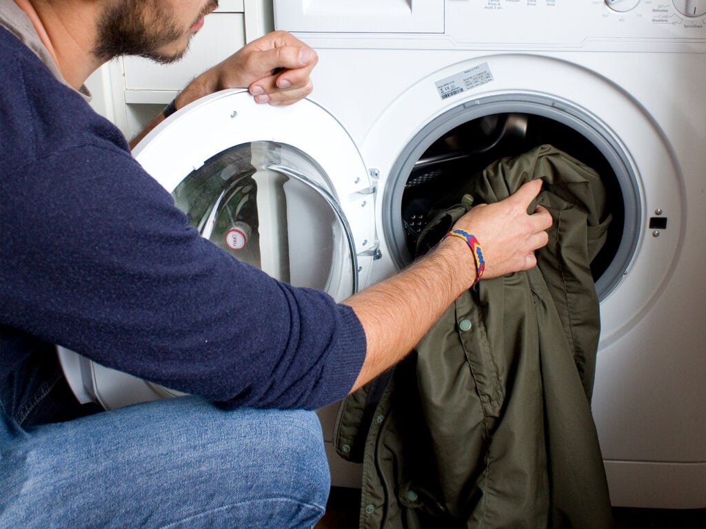 Waterproof jacket being put into a washing machine