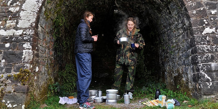 Young people cooking on a camping stove