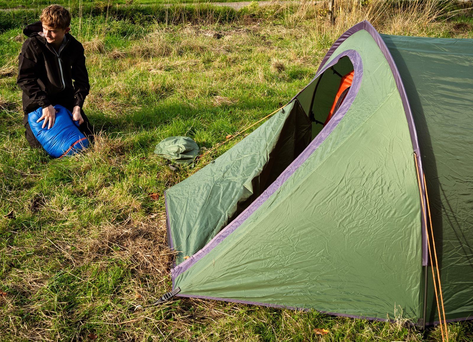 Young person setting up a tent