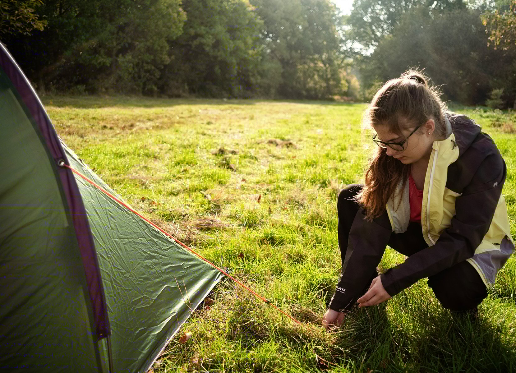 Young person putting up a tent