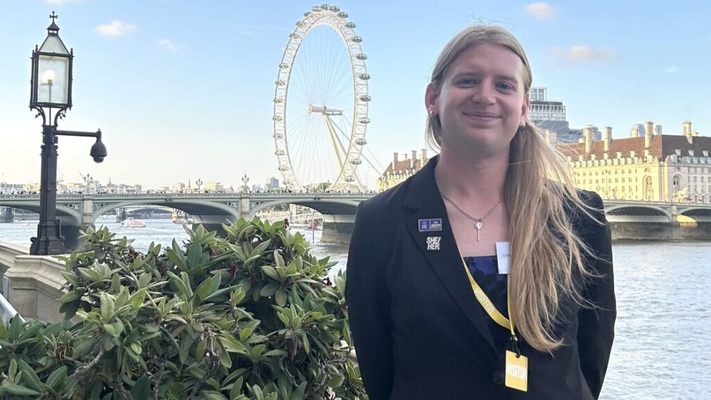Sophie is smiling standing in front of the Thames and London Eye.
