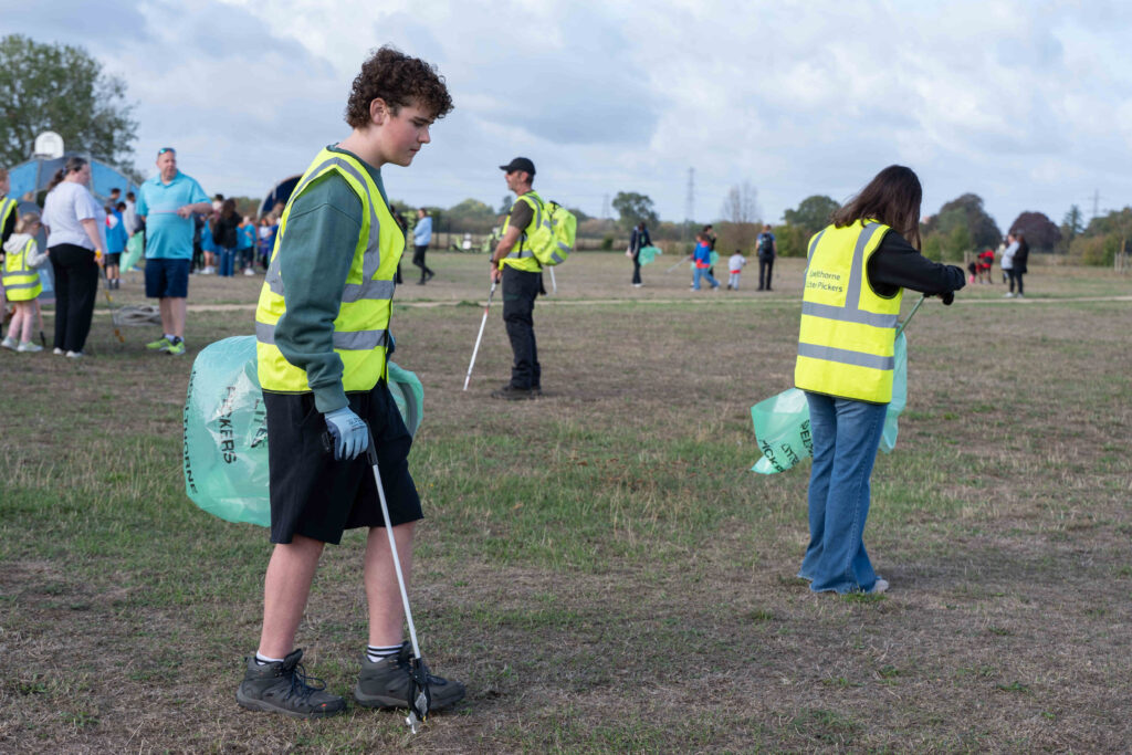 People taking part in a community litter pick in a grassy field.