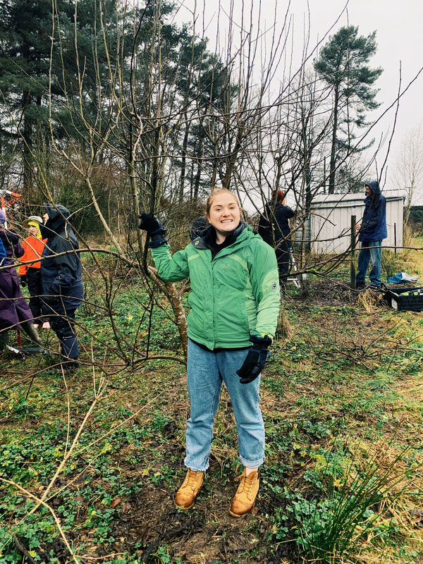 Laura smiling in a green jacket and denim jeans