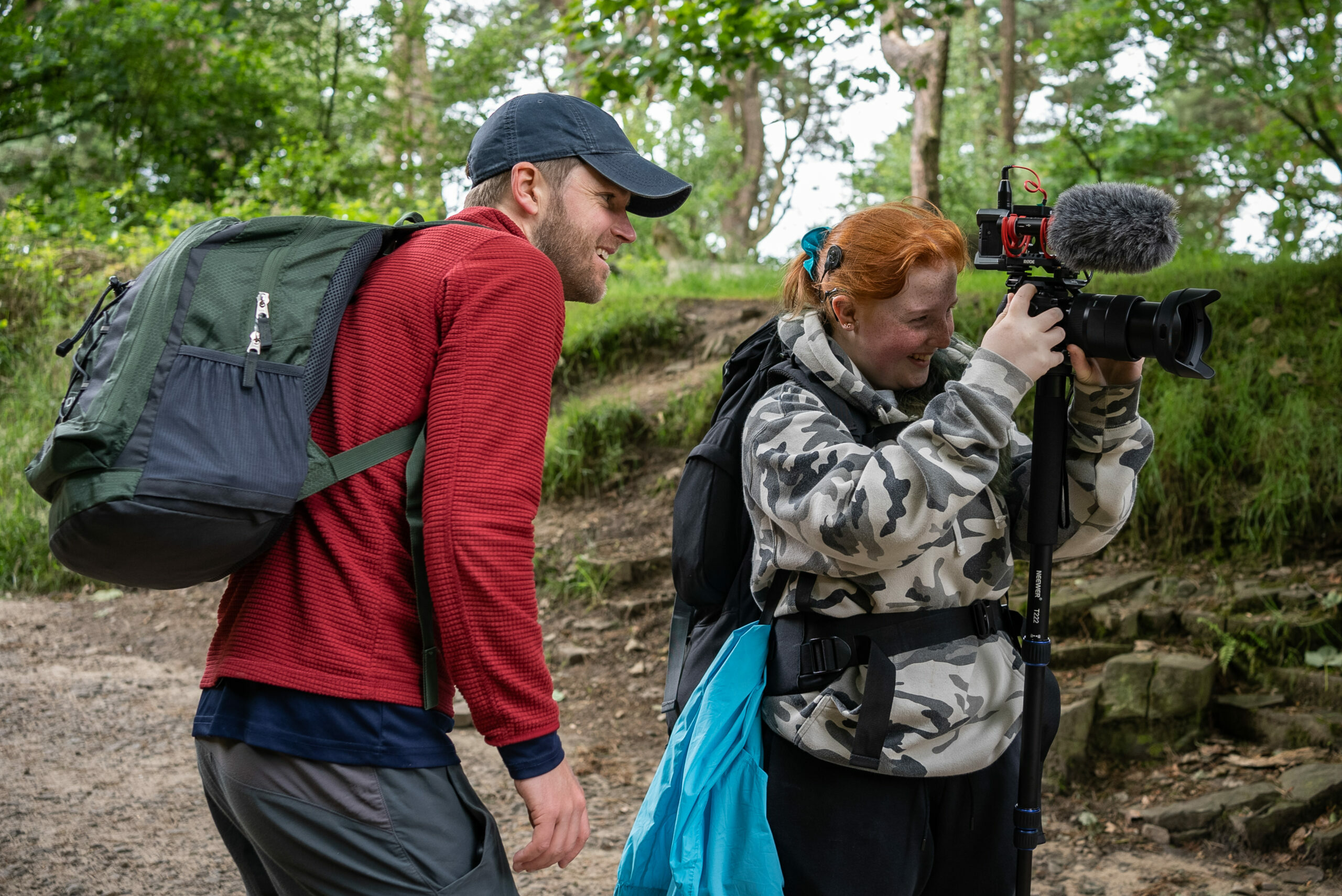 A D of E employee looking at a participant operating a camera with a microphone.