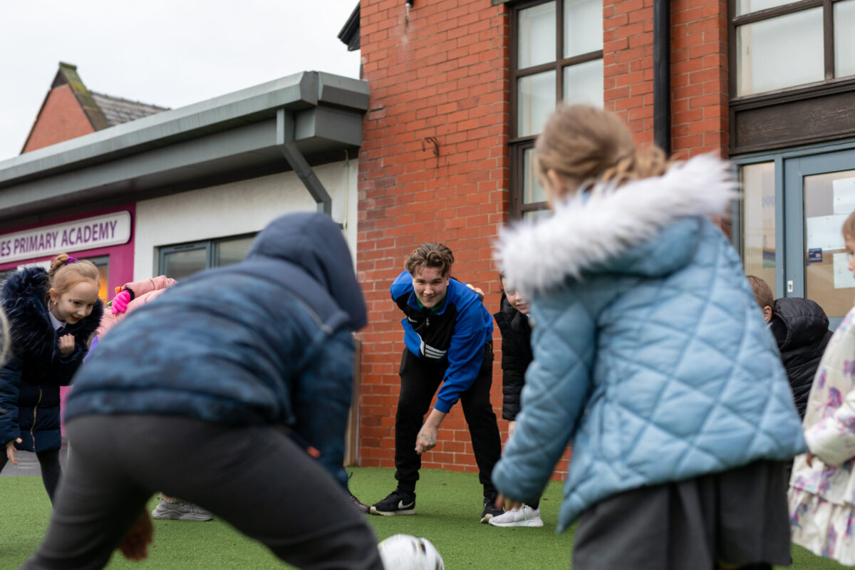 JayJay playing a game with pupils at a school where he volunteers.