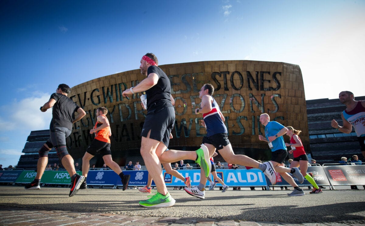 Marathon runners going past the Wales Millennium Centre.