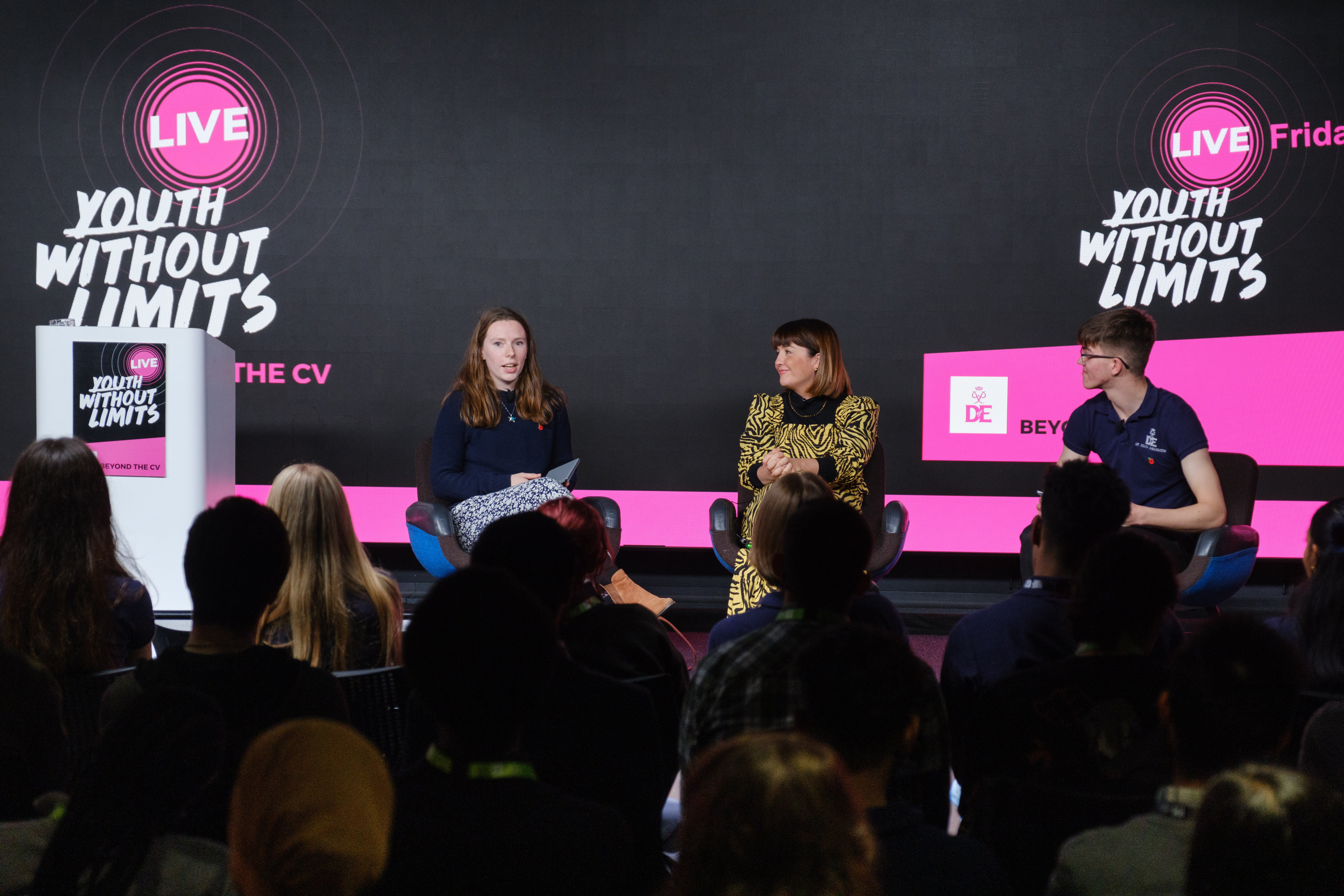 A panel discussion with three people on stage at Youth Without Limits Live.