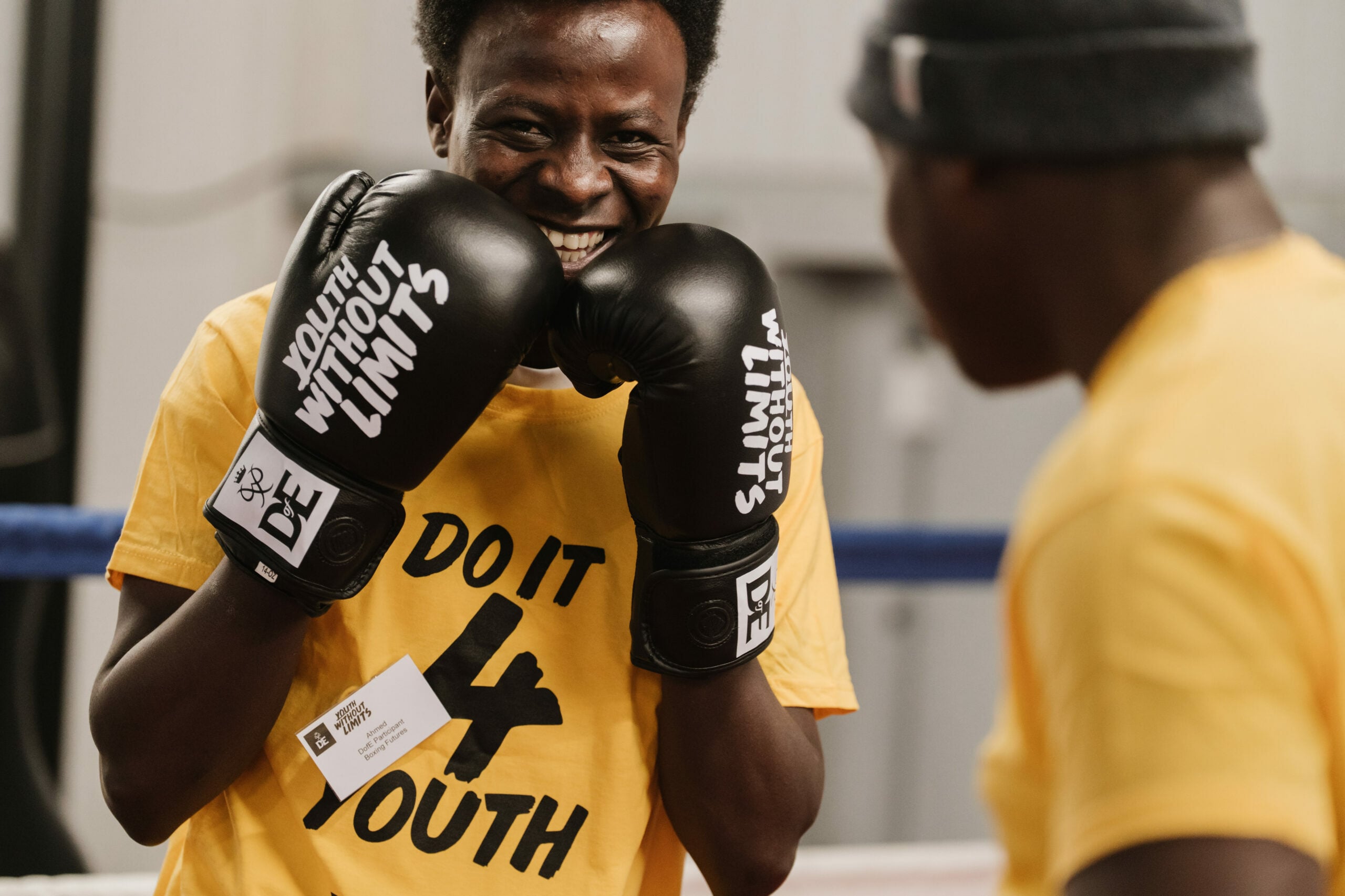 A young man wearing a bright yellow t-shirt with the text 