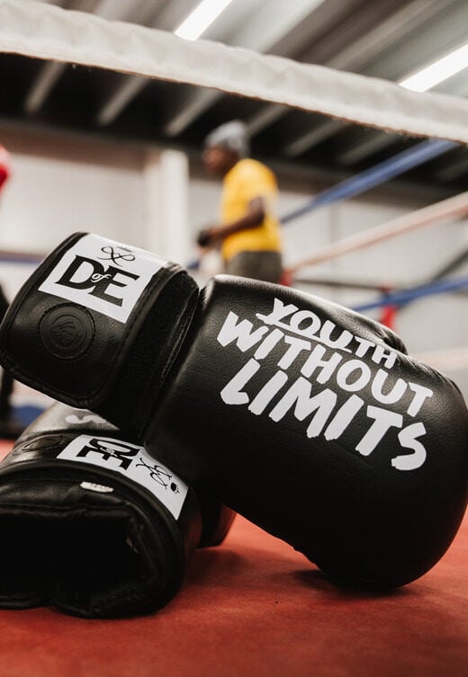 A pair of black boxing gloves with the text
