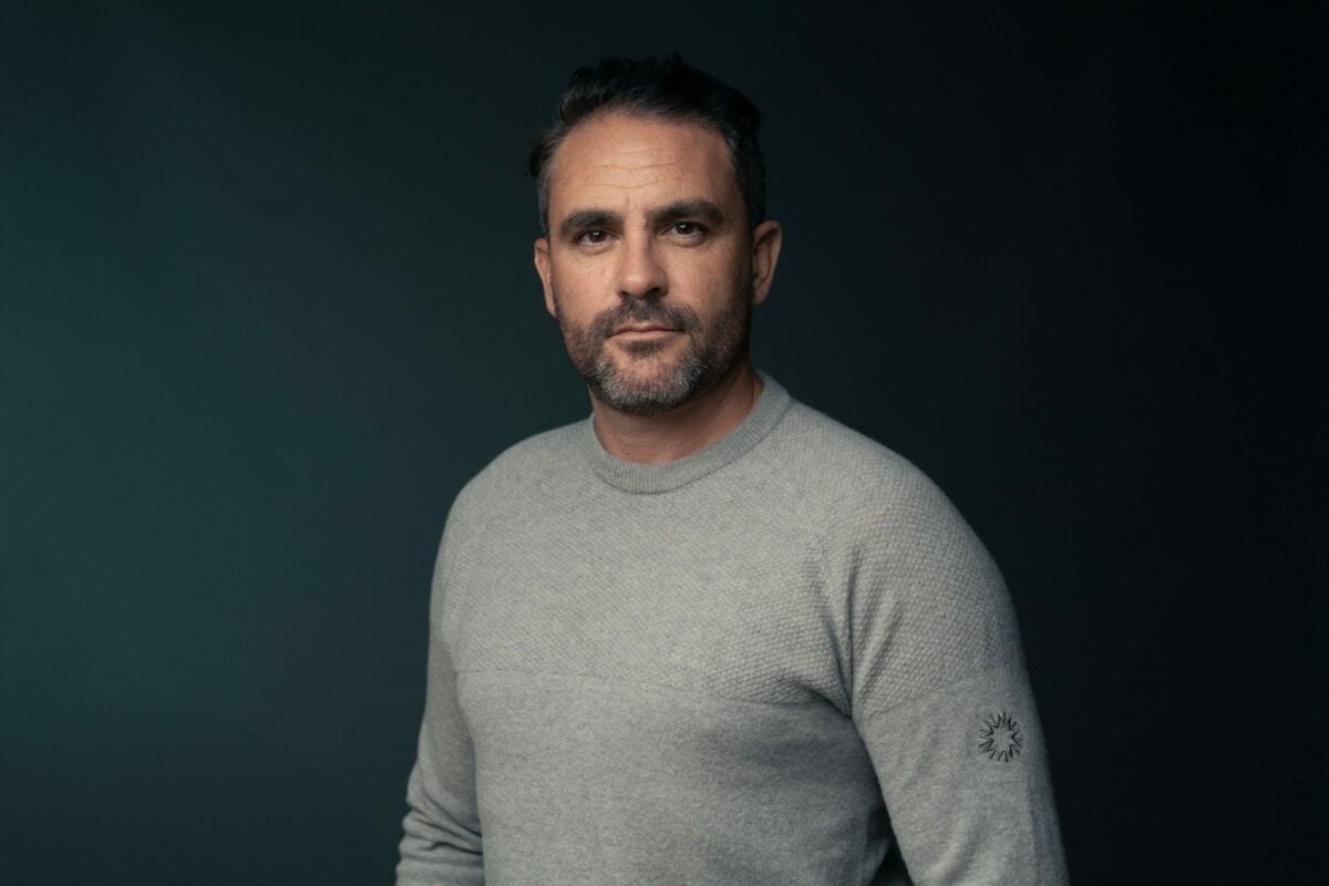 Levison wearing a gray jumper staring into the camera.