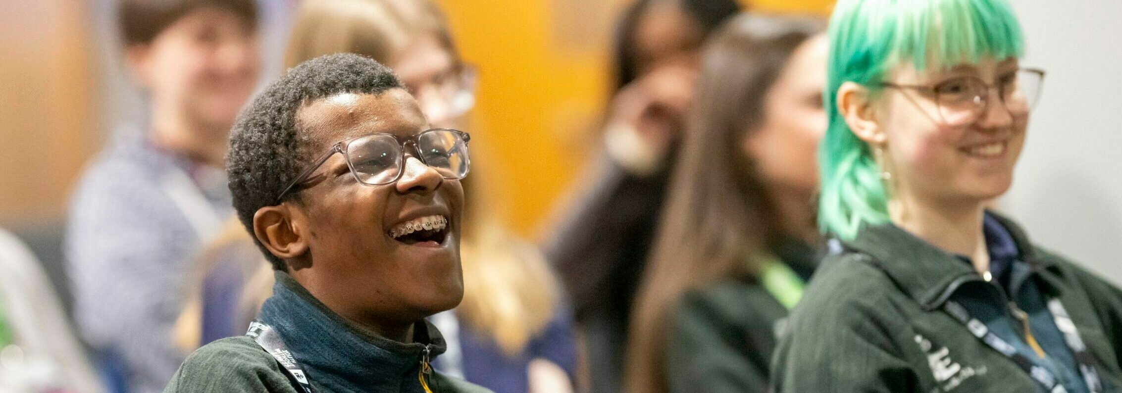 Two young people sitting down and laughing.