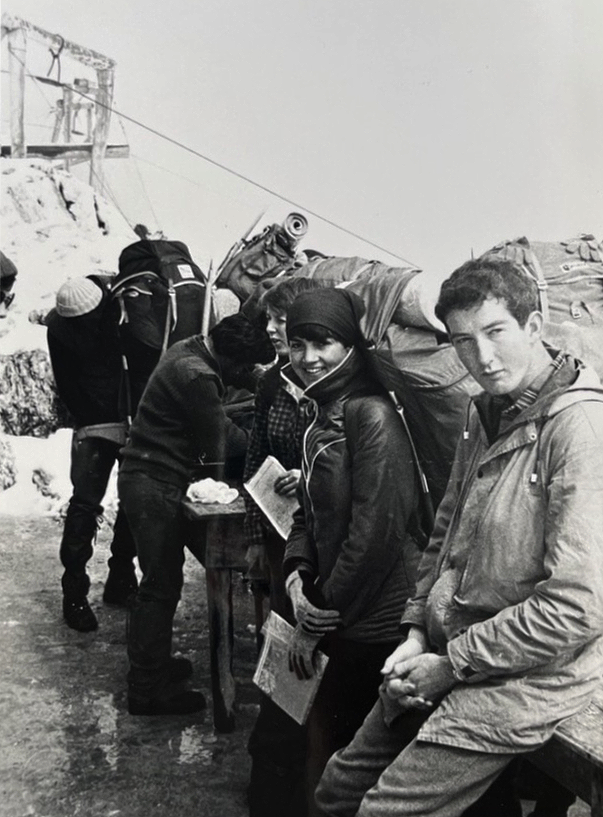 Black and white photo of five young people carrying rucksacks on their expedition.