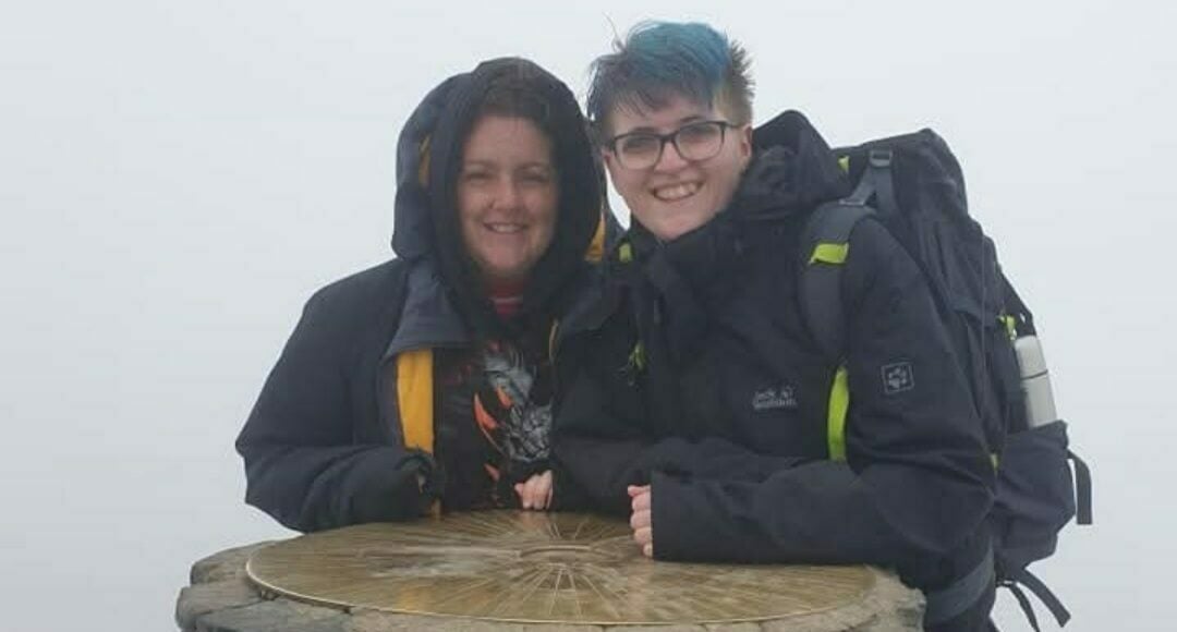 Michelle and Jay standing on top of a mountain surrounded by thick fog.