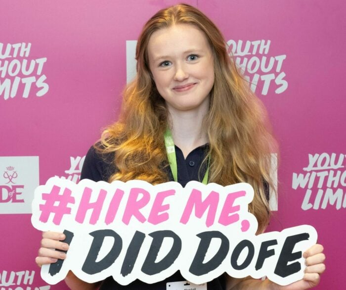 A Youth Ambassador holding a sign that says hire me, I did D of E.