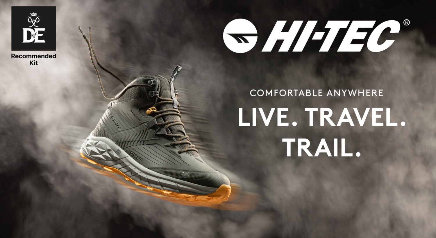 Promotional image for Hi-Tec hiking boots featuring a single grey and orange walking boot with rugged design and thick sole. Text reads ‘LIVE. TRAVEL. TRAIL.’ and ‘COMFORTABLE EVERYWHERE.’ Hi-Tec logo appears at the top right, and The Duke of Edinburgh’s Award ‘Recommended Kit’ logo is shown in the top left.