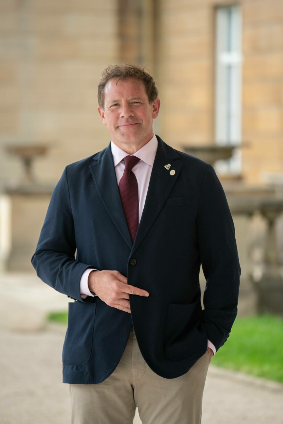 Matt wearing a suit standing outside Buckingham Palace.
