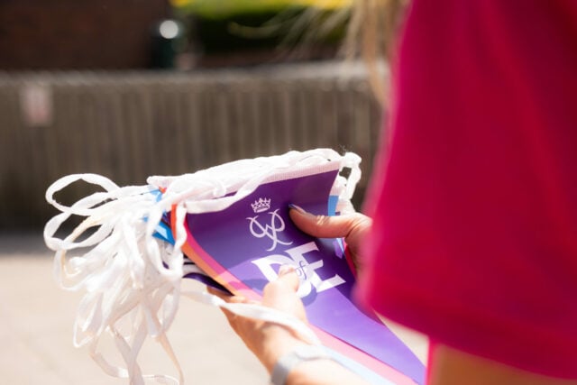 A person holding a colorful banner with the text 