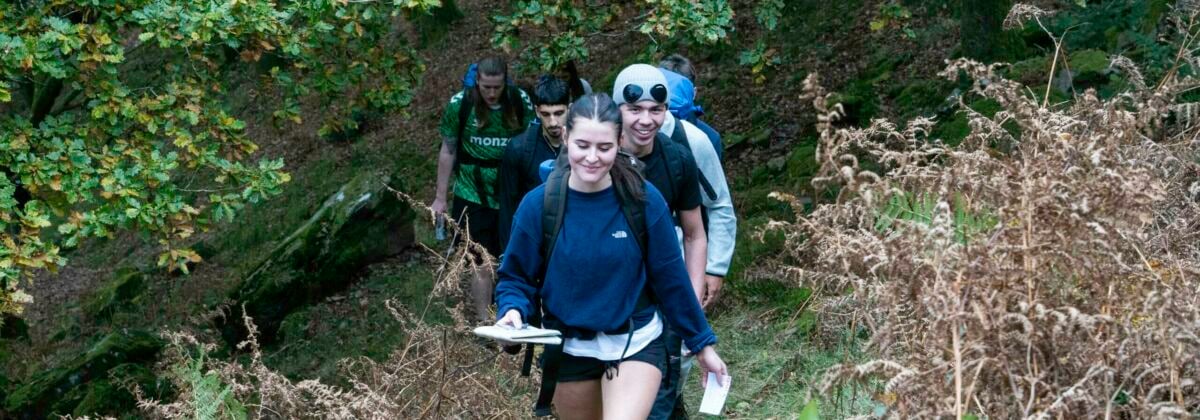 Young people on their expedition walking along a trail in a line.