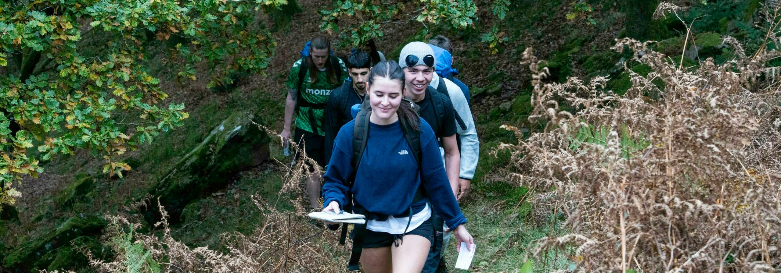 Young people on their expedition walking along a trail in a line.