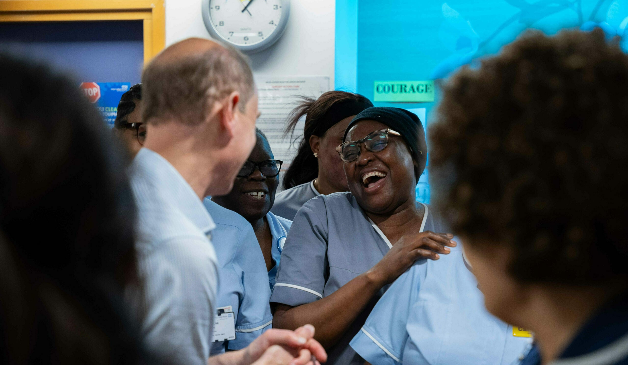 A nurse laughing among a group of people.