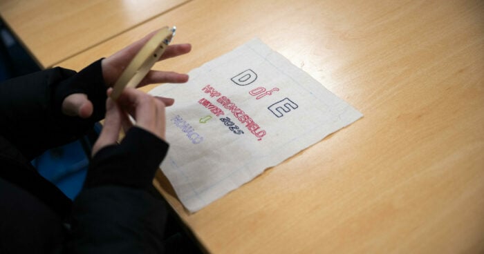 A piece of embroidery on a table that reads 